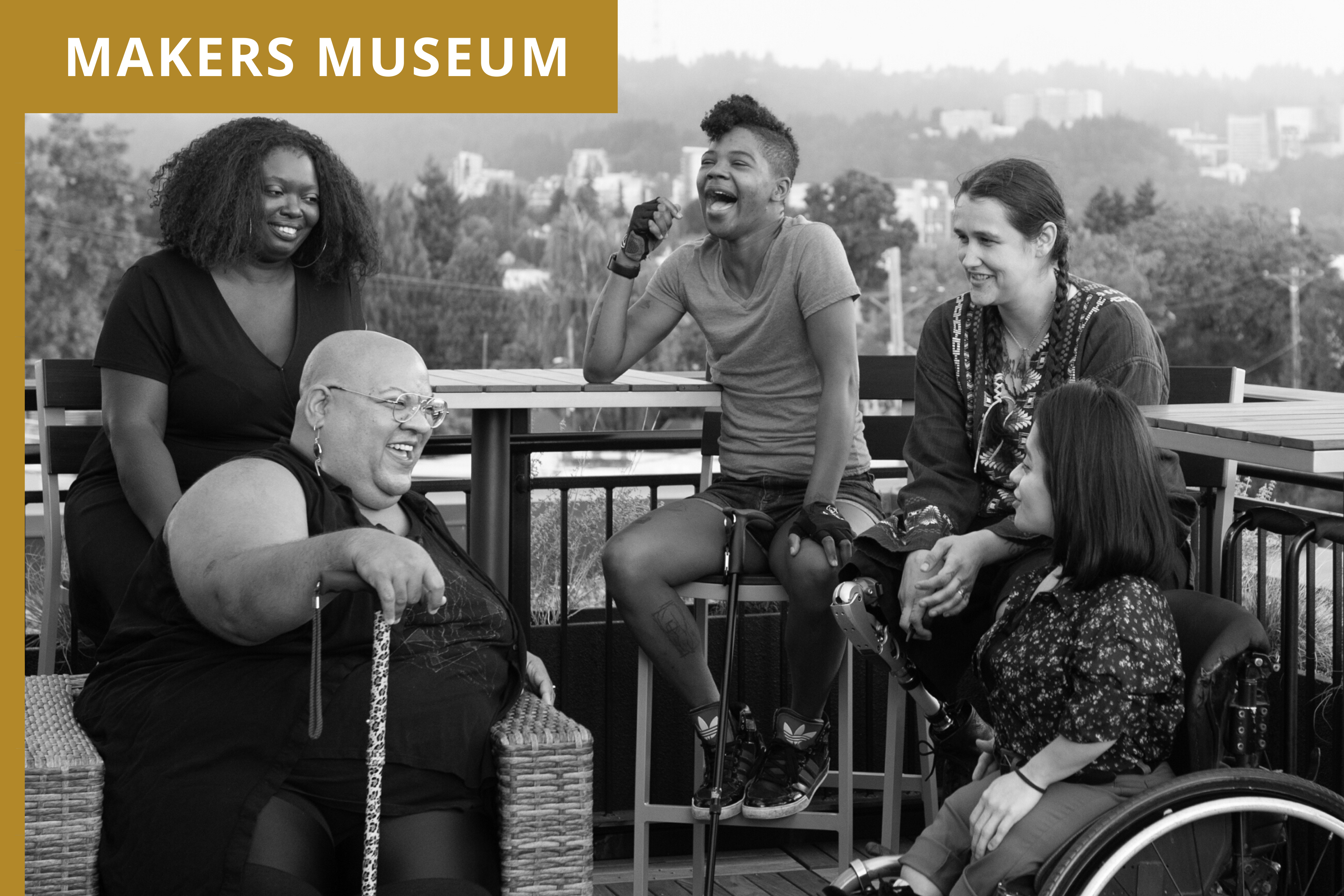 Five disabled people of color with canes, prosthetic legs, and a wheelchair sit on a rooftop deck, laughing and sharing stories. Greenery and city high-rises are visible in the background. Brown label in the top right corner with the project title, Makers Museum.